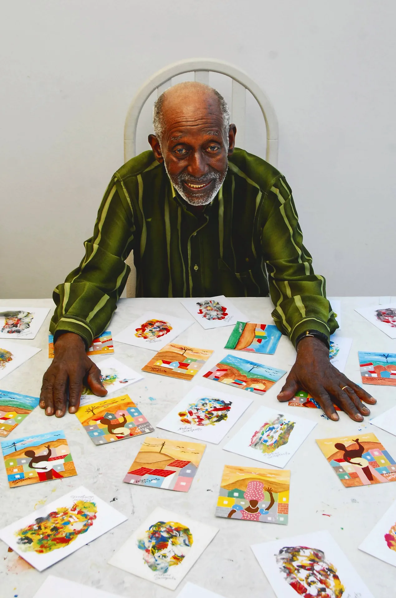 Nelson Sargento diante de pequenos trabalhos de sua produção artística.